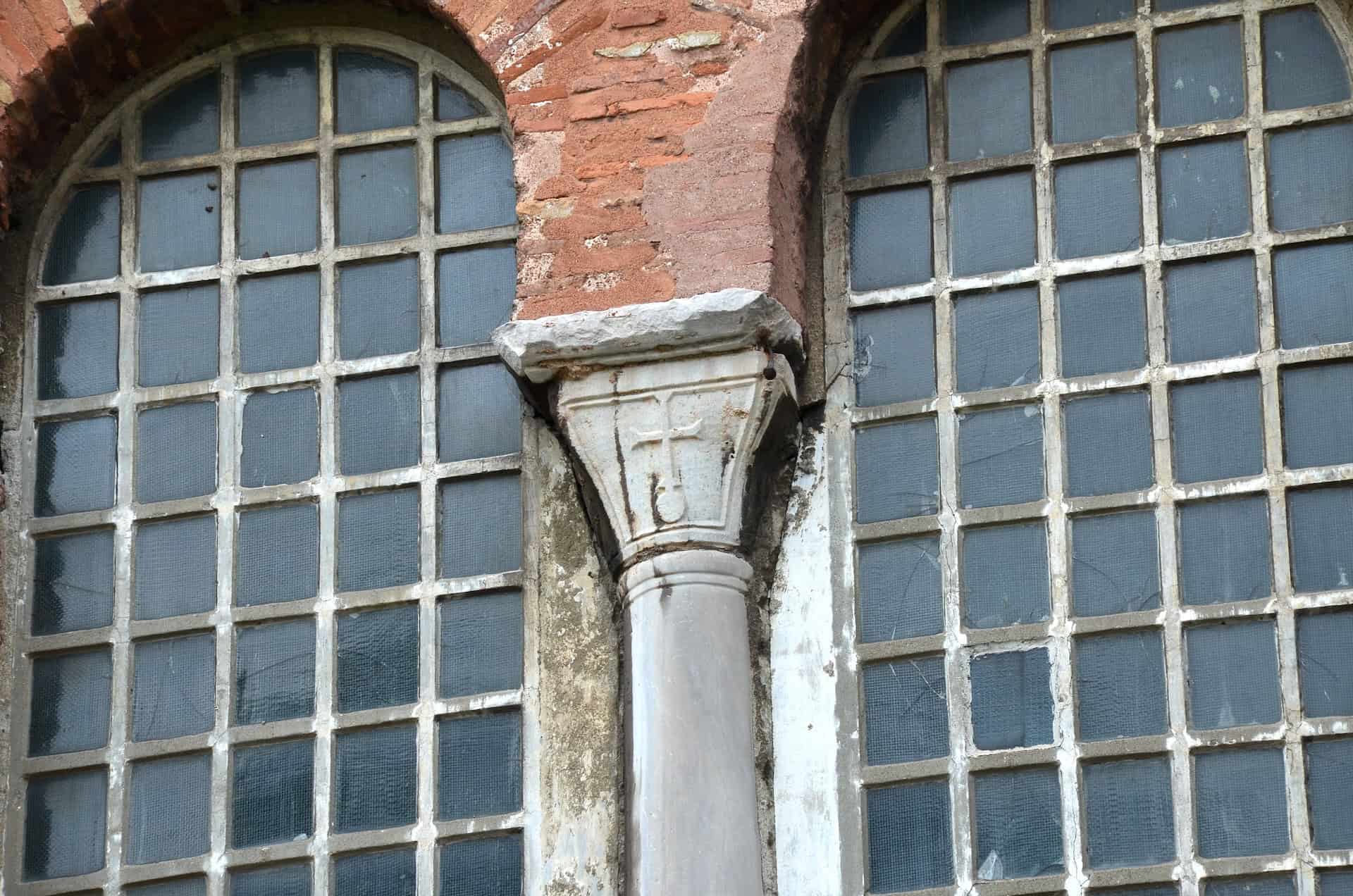 Column decorated with a cross on an arched window