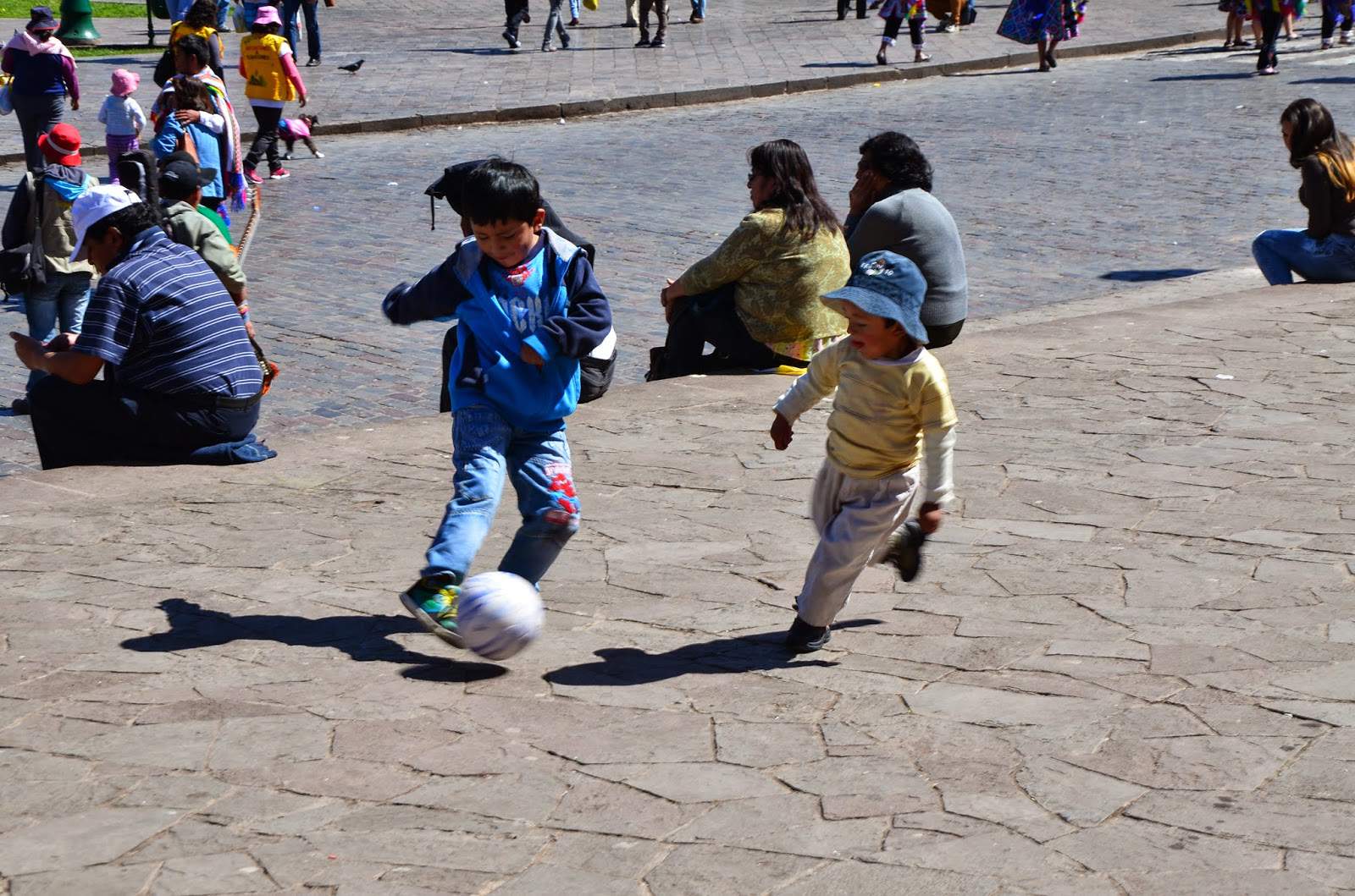 Children playing football in Plaza de Armas in Cusco, Peru