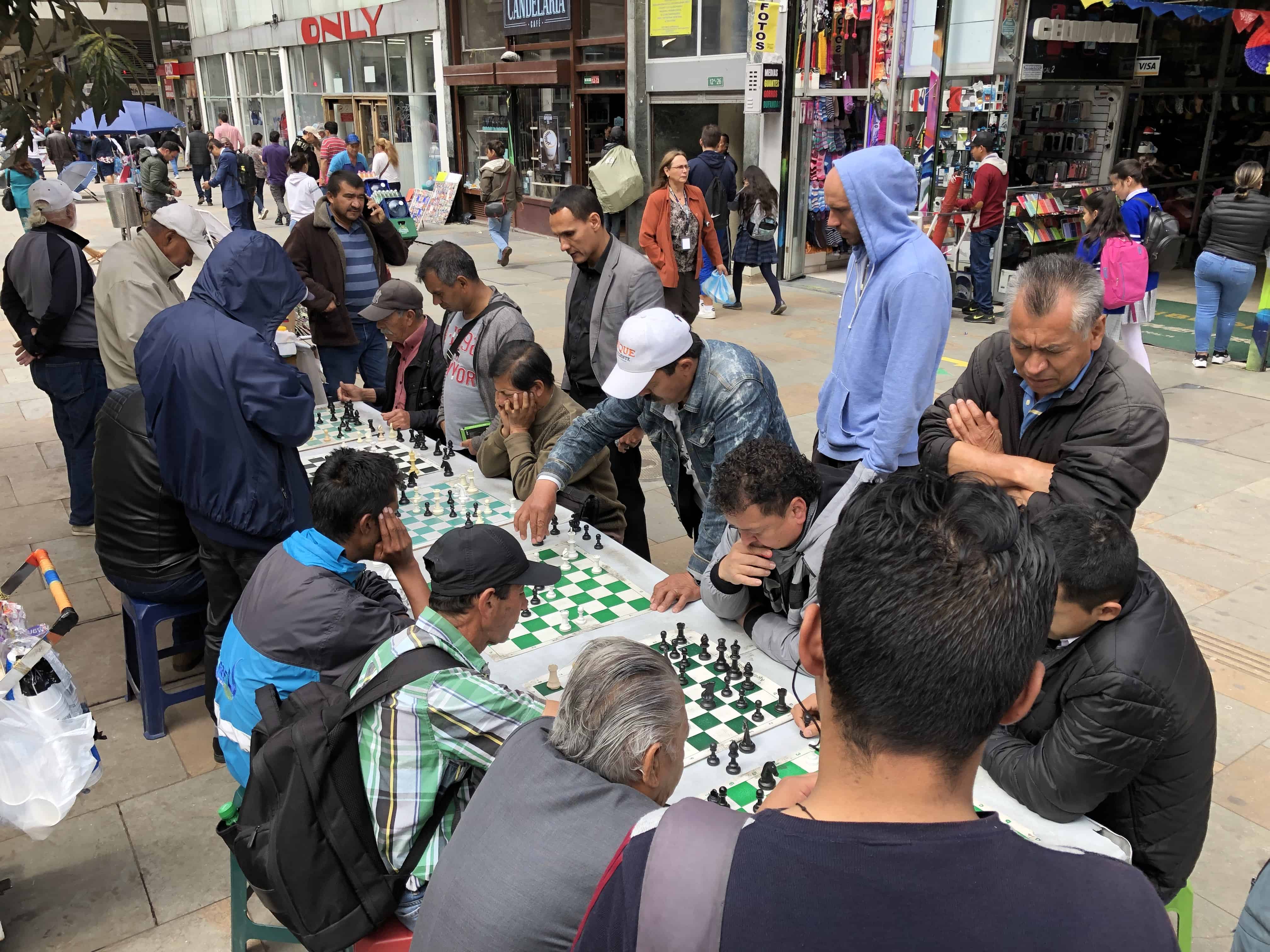 Men playing chess on Carrera 7 in La Candelaria, Bogotá, Colombia