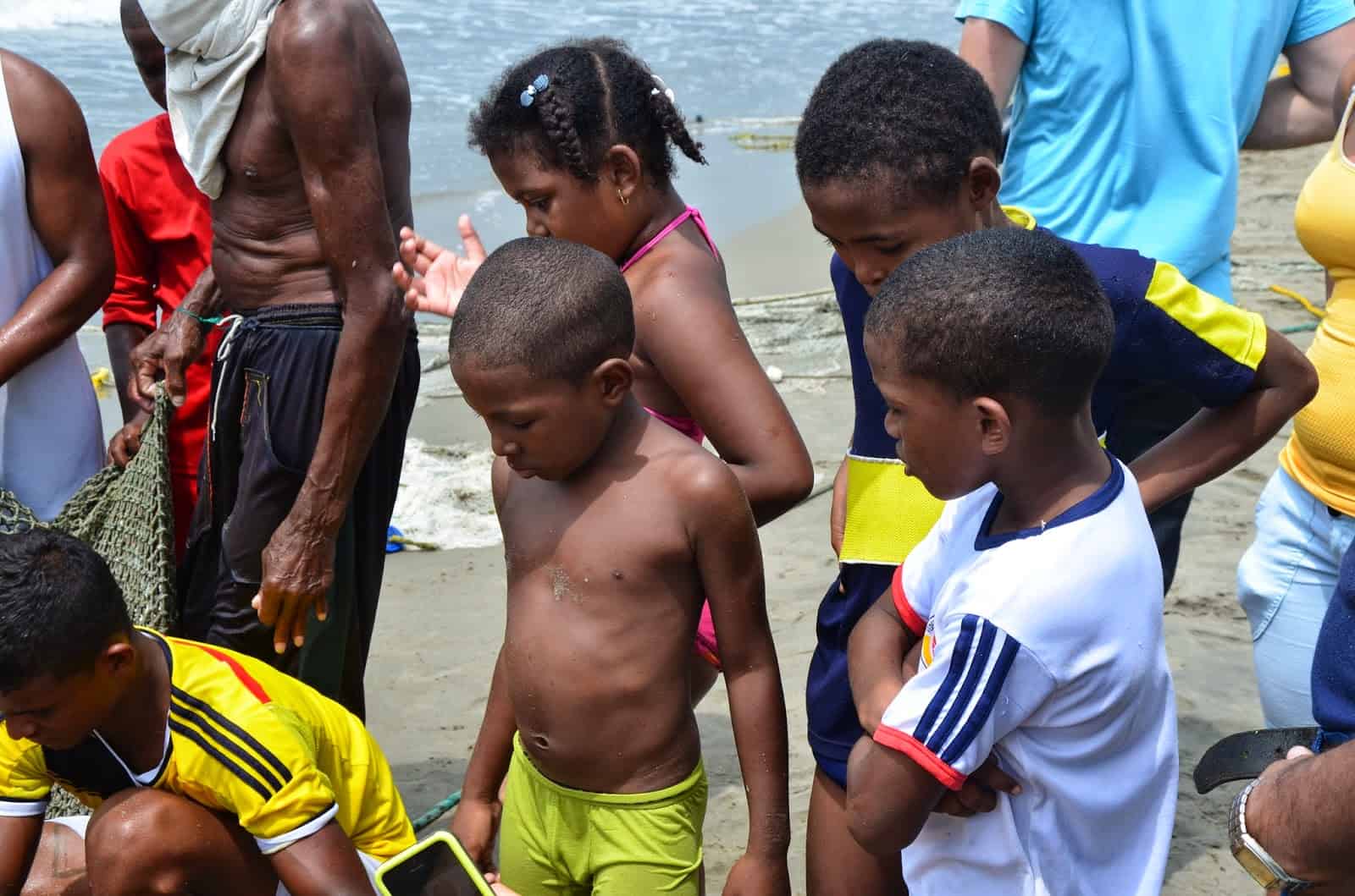 Children watching the fishermen Fishermen emptying the nets at Manzanillo del Mar, Bolívar, Colombia