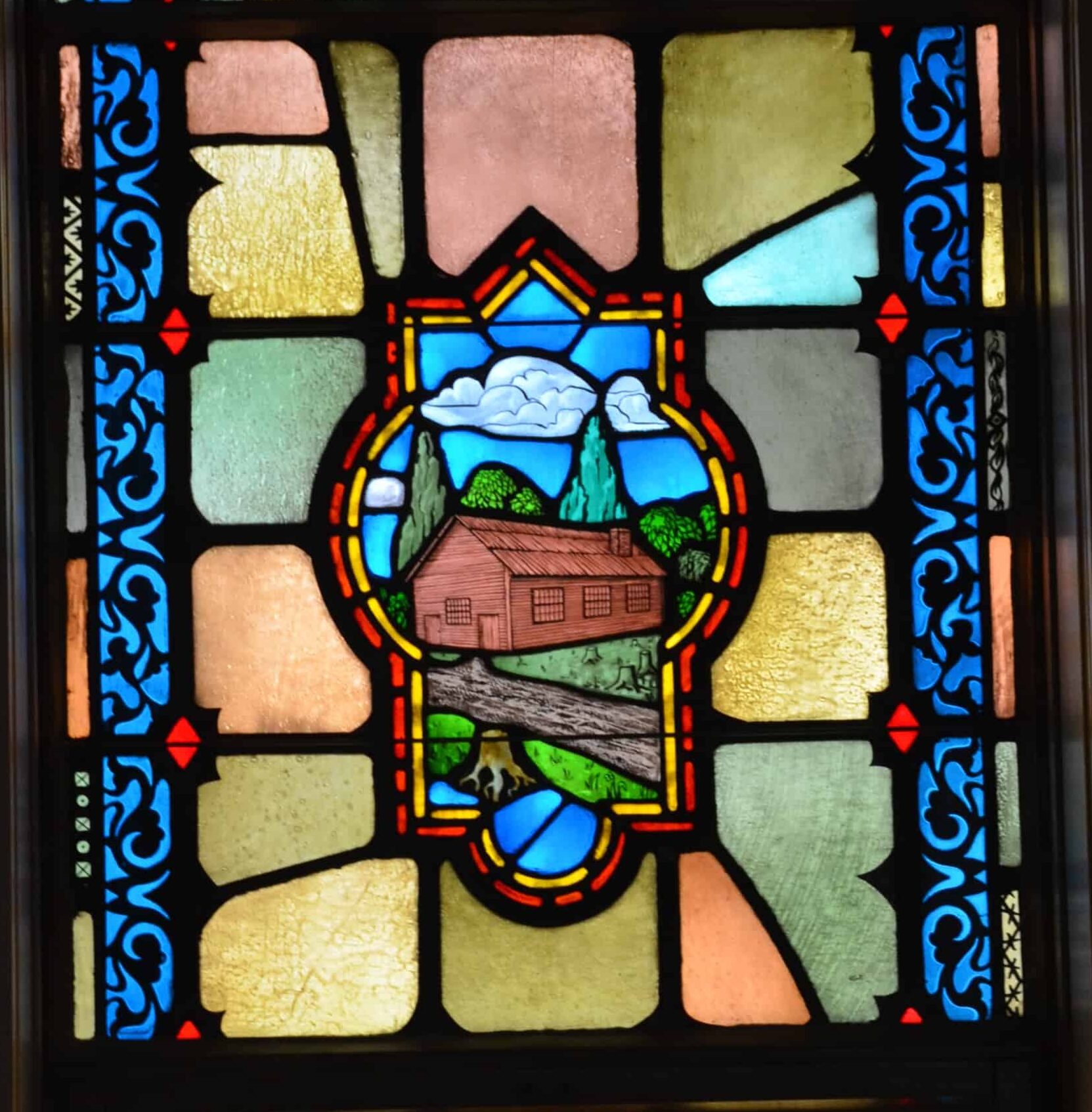 Stained glass window depicting the first log cabin church on the Chicago River in the Chapel in the Sky at the Chicago Temple