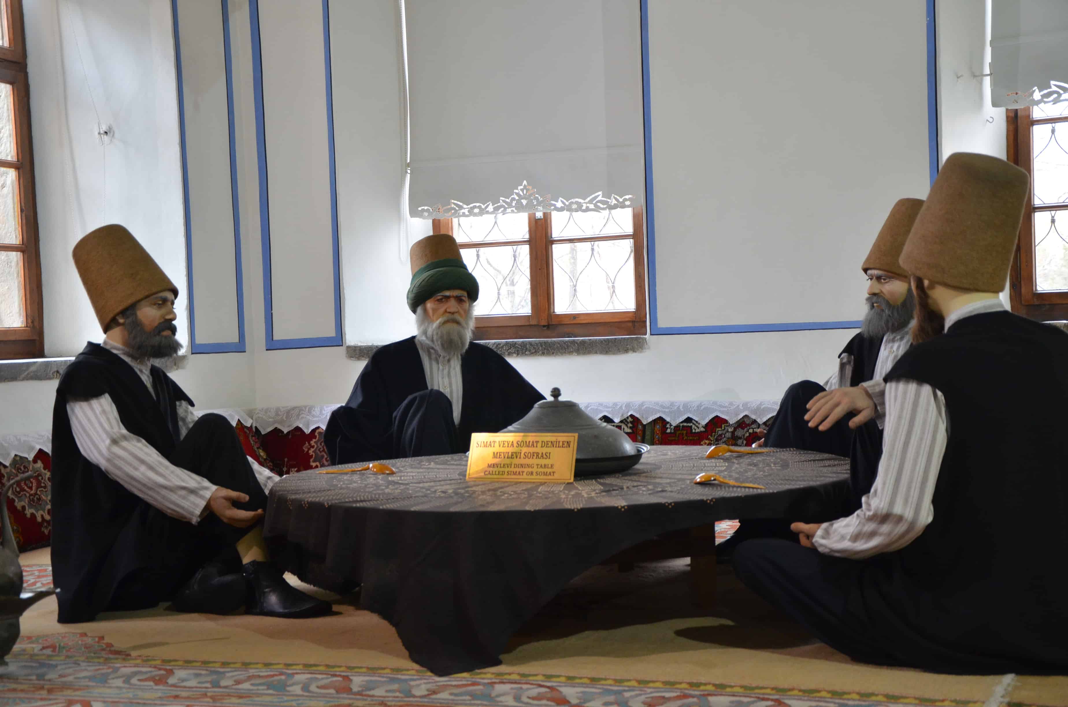 Dervishes sitting around a table in the kitchen at the Mevlana Museum in Konya, Turkey