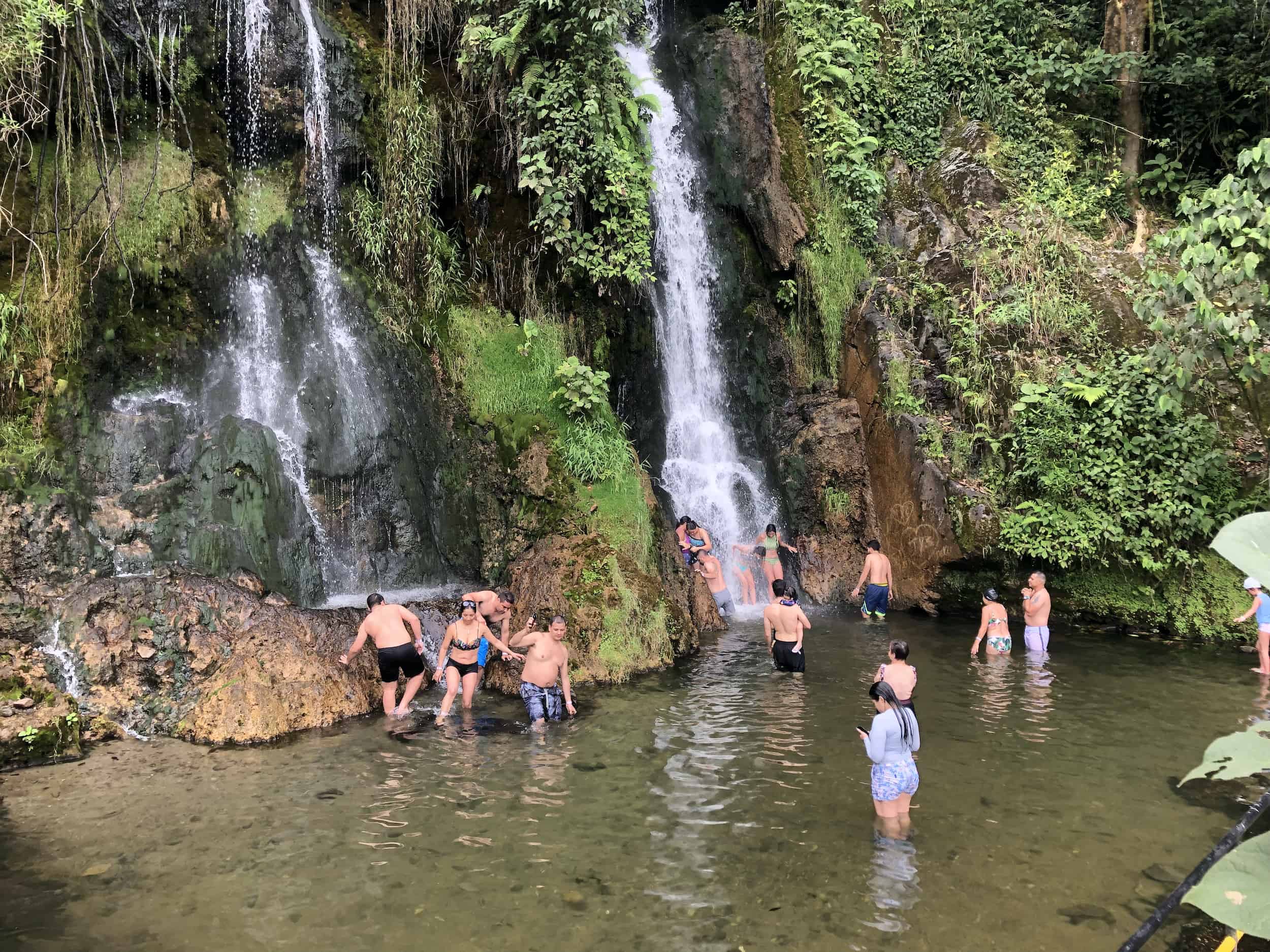 Visitors in the waterfall plunge pool at Balneario de Santa Rosa