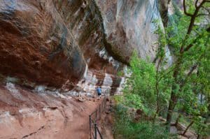 Walking under the cliffside on the Emerald Pools Trail at Zion National Park in Utah