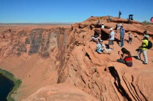 Visitors taking pictures at the edge of the cliff at Horseshoe Bend at Glen Canyon National Recreation Area in Arizona