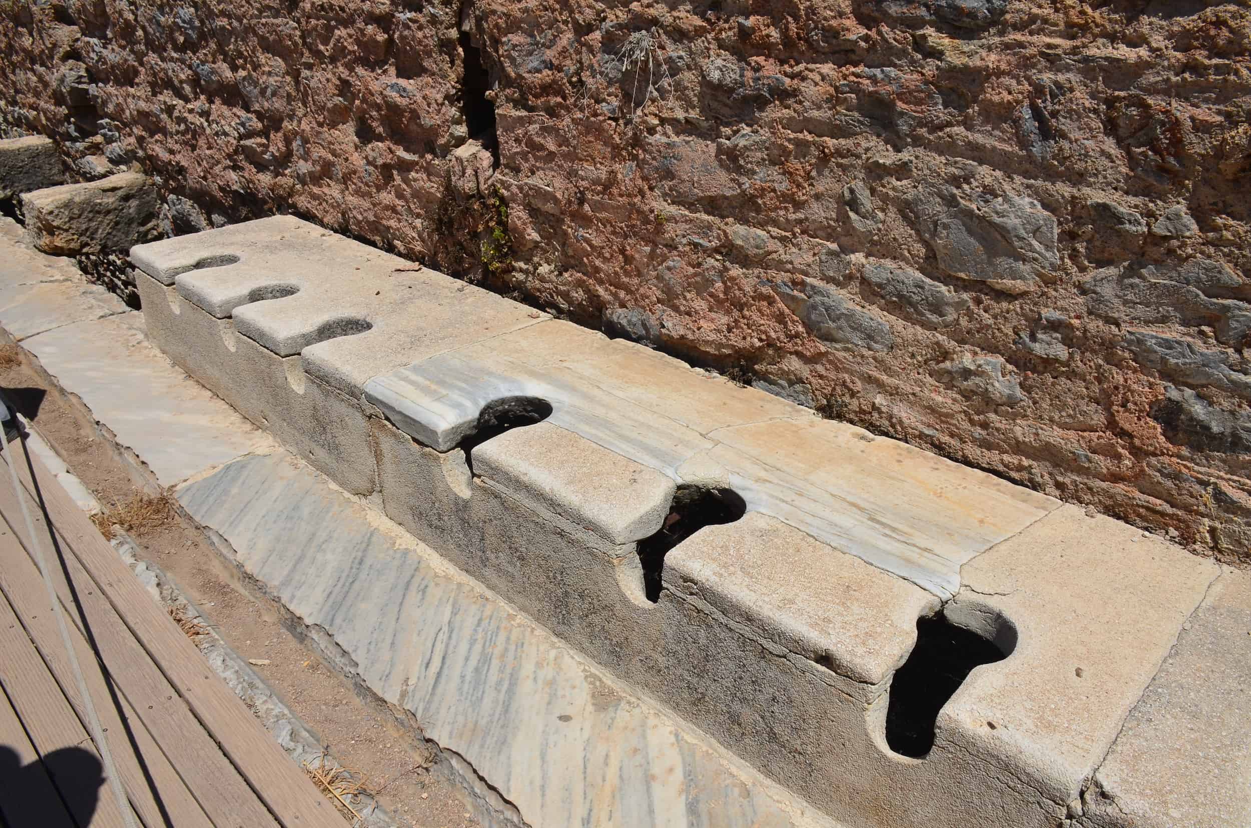 Row of toilets at the Latrines on Curetes Street in Ephesus