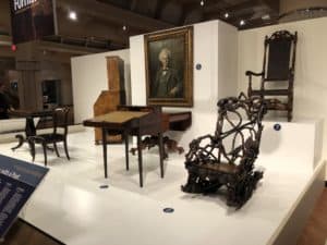 Portable writing desk owned by Edgar Allan Poe (left) and rocking chair owned by Cornelius Vanderbilt (right) at The Henry Ford Museum of American Innovation in Dearborn, Michigan