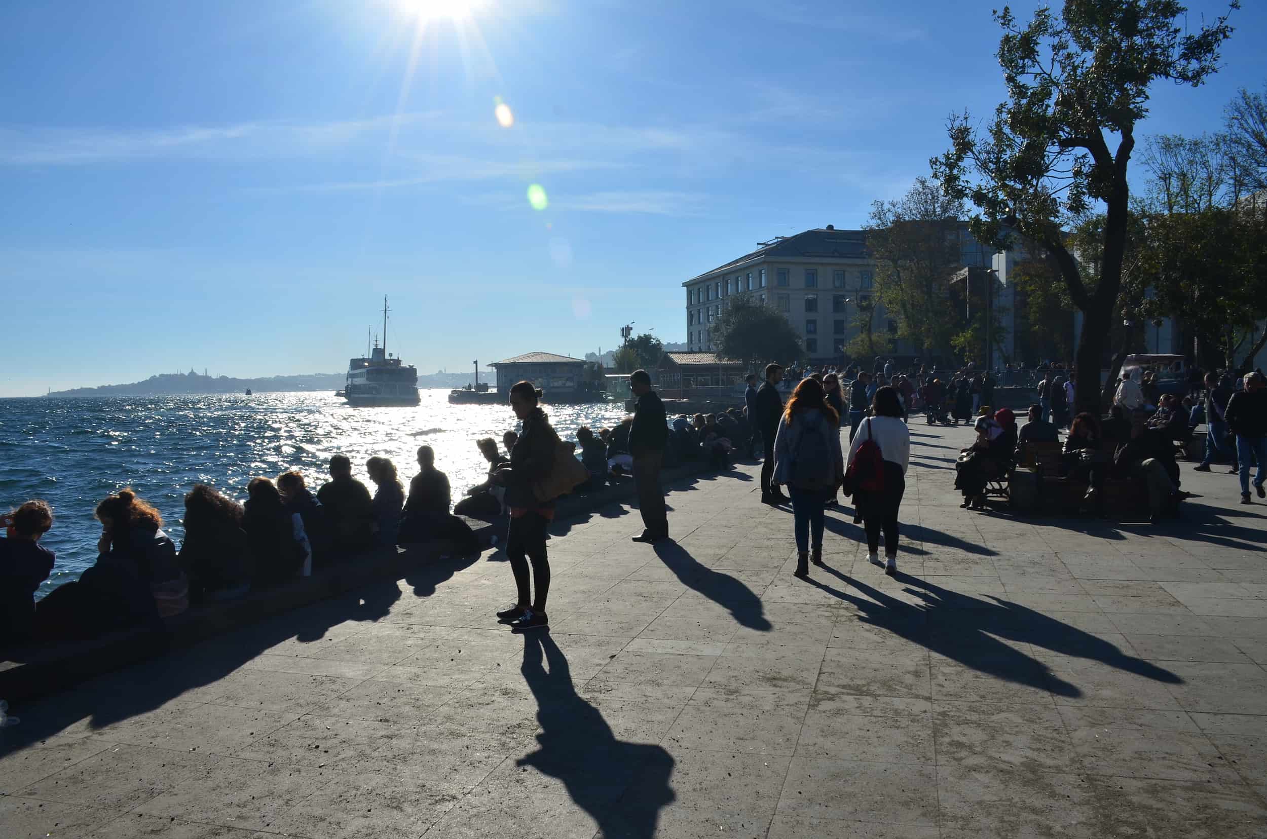 People sitting along the Bosporus at Barbaros Park in Beşiktaş, Istanbul, Turkey