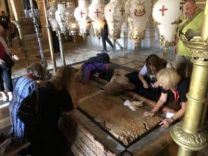 Christians collecting oil at the Stone of Unction at the Church of the Holy Sepulchre in Jerusalem