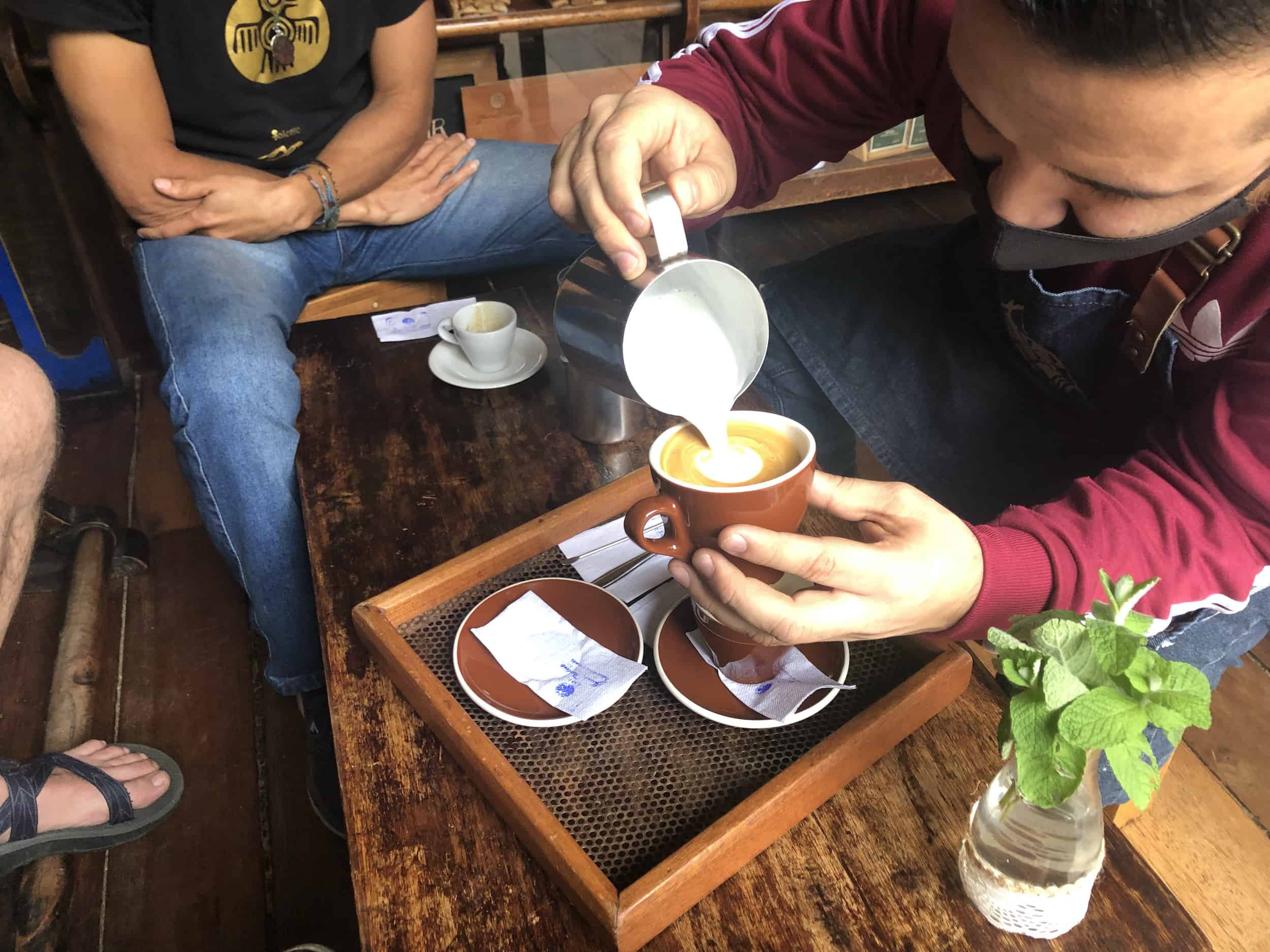 Pouring the milk to make cappuccino on the Café Jesús Martín Coffee Tour in Salento, Colombia