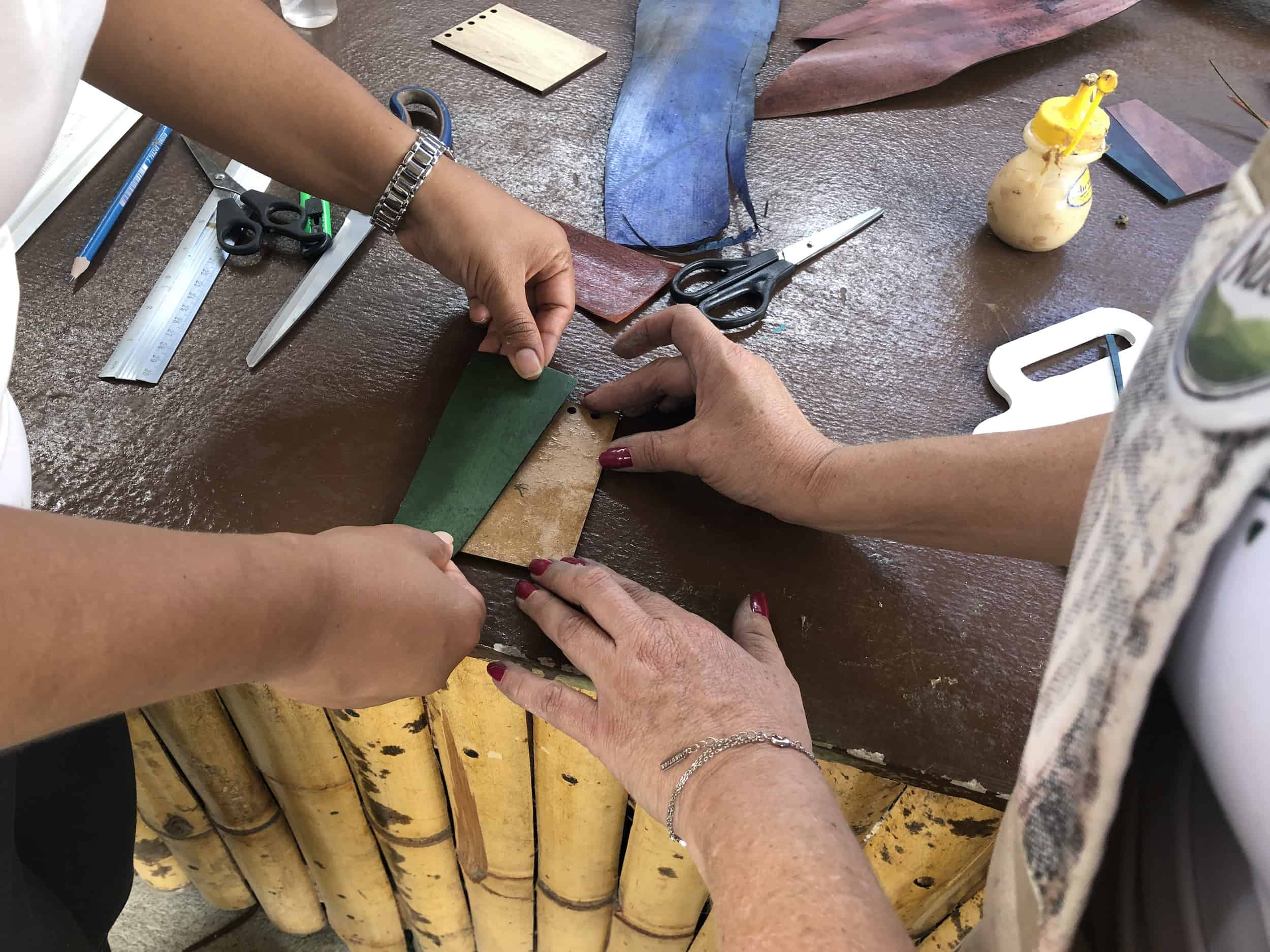 Gluing the pieces onto the wood on the Bamboo and Guadua Educational Hike