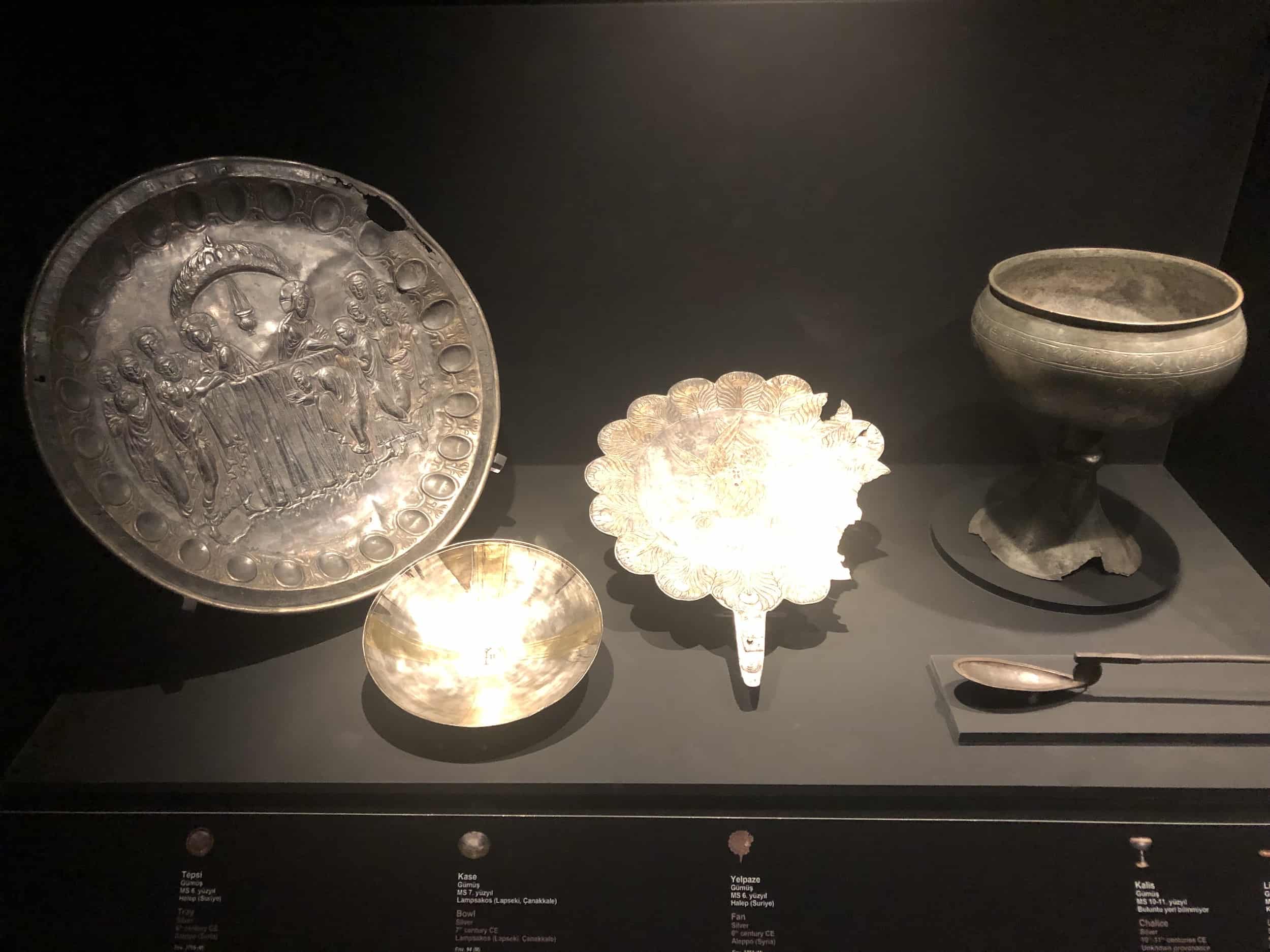 Silver tray from Aleppo, Syria, 6th century (left); silver bowl from Lampsakos, 7th century (left center); and silver fan from Aleppo, 6th century (center)