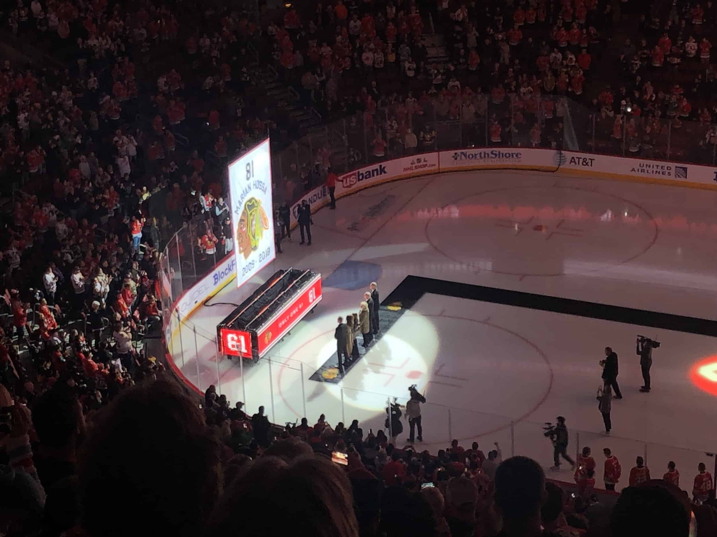 Hossa and his family standing in front of the banner during the Marian Hossa jersey retirement ceremony at the United Center in Chicago, Illinois