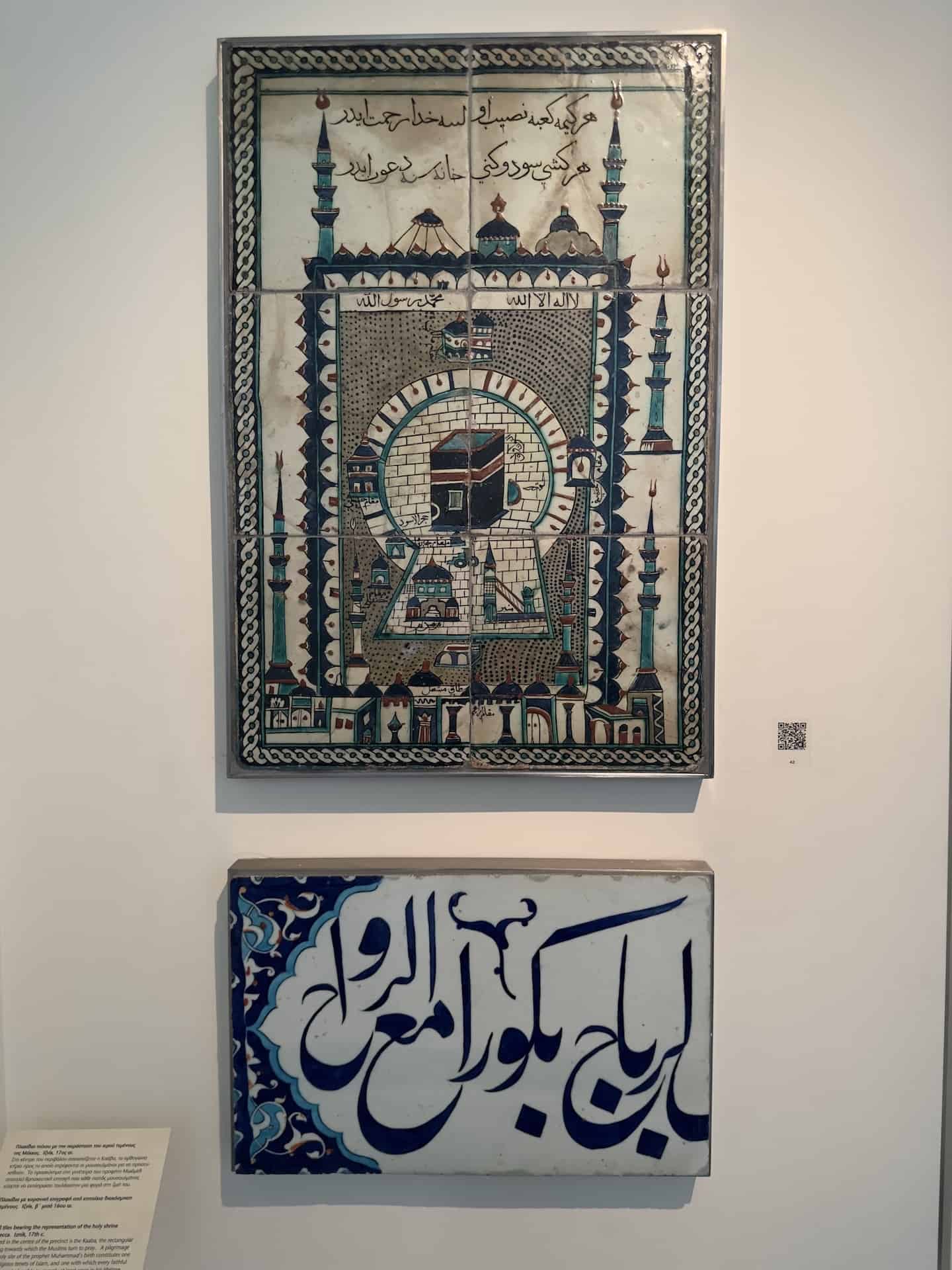 Wall tiles bearing the representation of the holy shrine of Mecca; Iznik; 17th century (top) and Tile with a Quranic inscription from the wall decoration of a mosque; Iznik; second half of the 16th century (bottom) at the Benaki Museum of Islamic Art in Athens, Greece