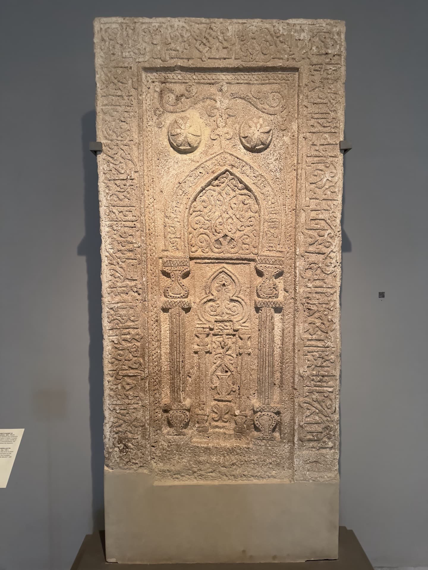 Stone mihrab bearing a floriated Kufic inscription and the representation of a hanging mosque lamp; Iran; 12th century at the Benaki Museum of Islamic Art in Athens, Greece