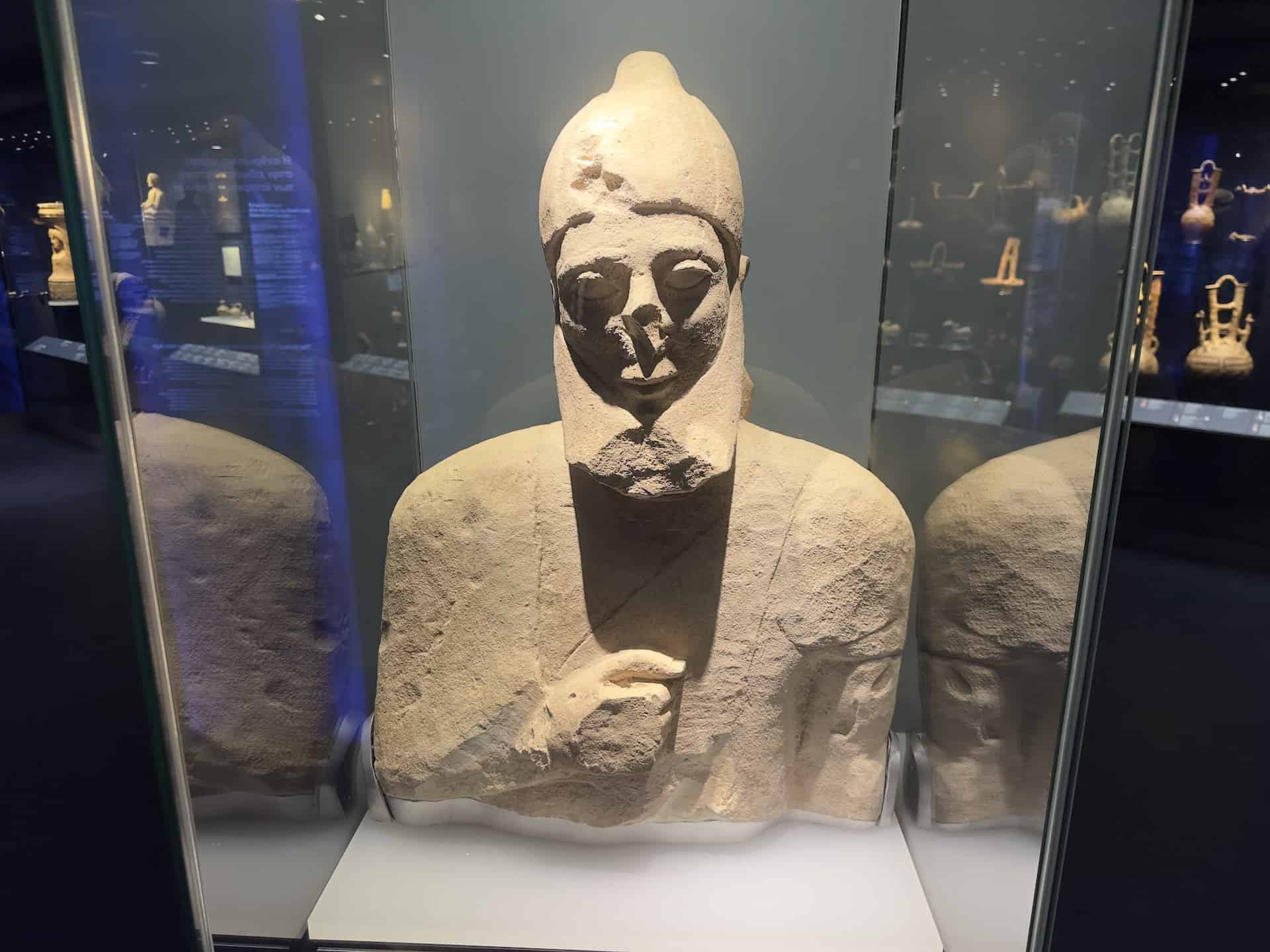 Bust of bearded male figure wearing a conical crested cap; limestone; Cypro-Archaic II, mid 6th century BC in Cypriot Culture at the Museum of Cycladic Art in Athens, Greece