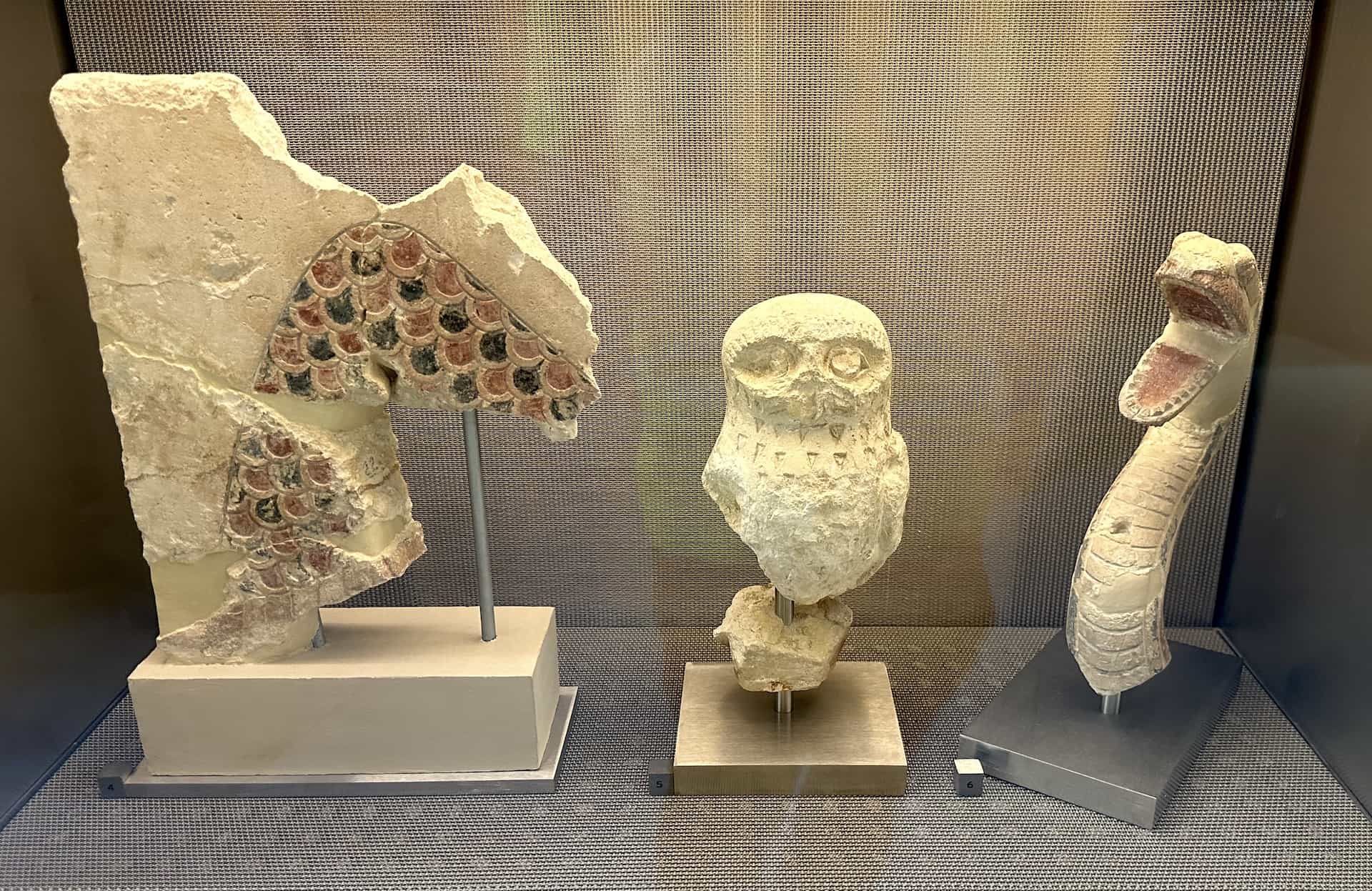 Fragments of the cornice (left) and owl and snake sculptures (center and right) from the Hekatompedon