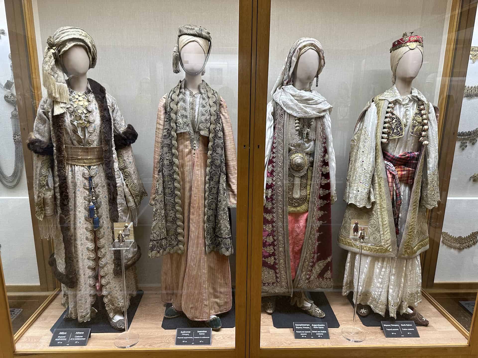 Costume of a noblewoman from Athens, 18th century (left); costume of a noblewoman from Ioannina, 18th century (center left); bridal and festive costume from Argyrokastro, 18th century (center right); and festive costume from North Epirus, 19th century (right) at the National Historical Museum in Athens, Greece