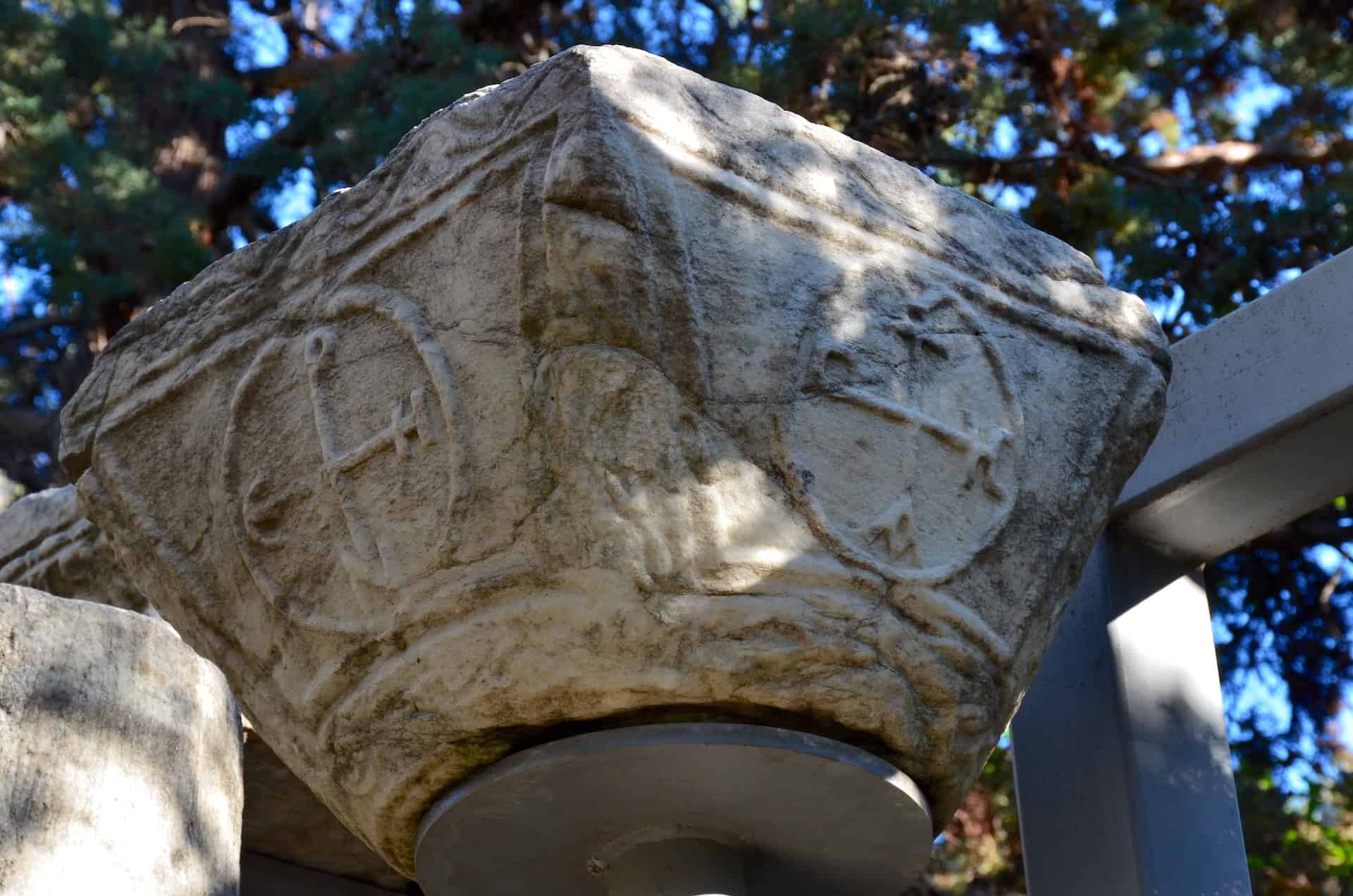 Column capital with the abbreviated inscription "Mother of God, please aid Empress Irene", 8th century AD in the Byzantine Church in the Paradise exhibit in the gardens at Villa Ilissia (Byzantine Museum) in Athens, Greece