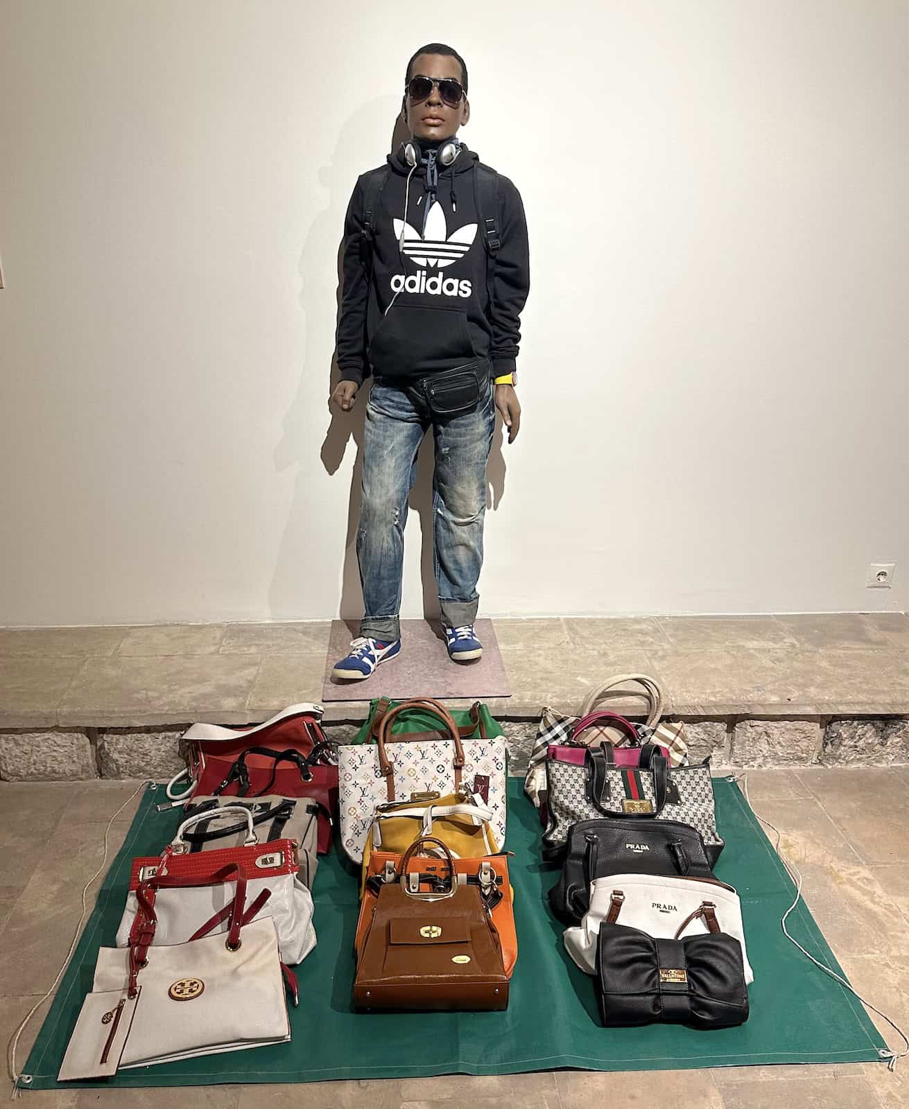 The Monument of an Illegal Street Vendor, Halil Altındere, 2012, wax sculpture and fake luxury brand handbags