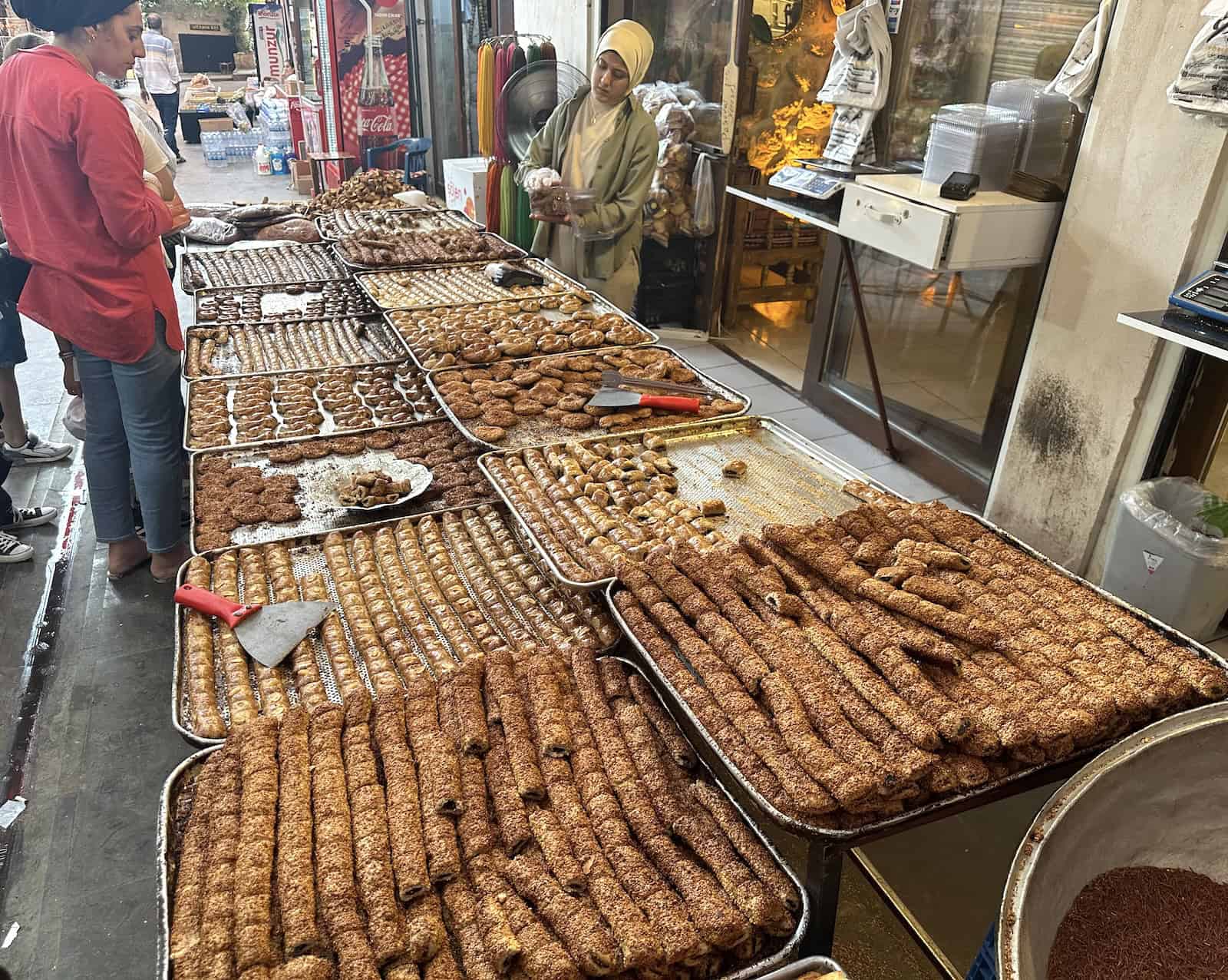 A woman selling local pastries in the bazaar in Mardin, Turkey